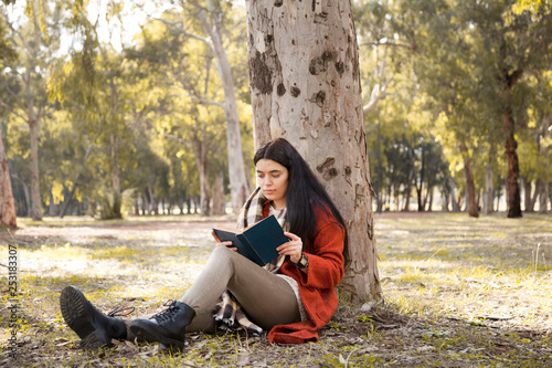 Young woman reading book in outdoors photo