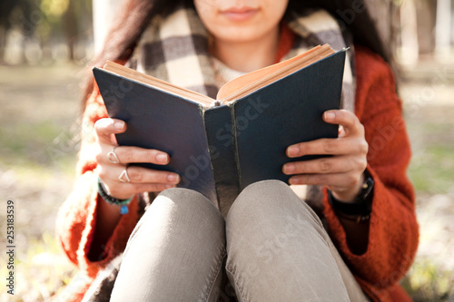 Young woman reading book in outdoors photo