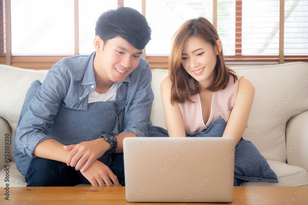 Asian young couple using laptop computer think and searching internet together, man and woman casual smiling work at home with happy and relax, communication and business concept. Asian young couple using laptop computer think and searching internet together, man and woman casual smiling work at home with happy and relax, communication and business concept.