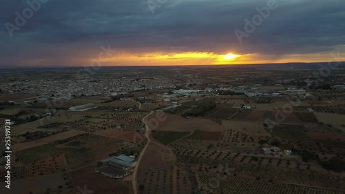 Aerial view of sunset over vineyards, pines and fields a stormy day