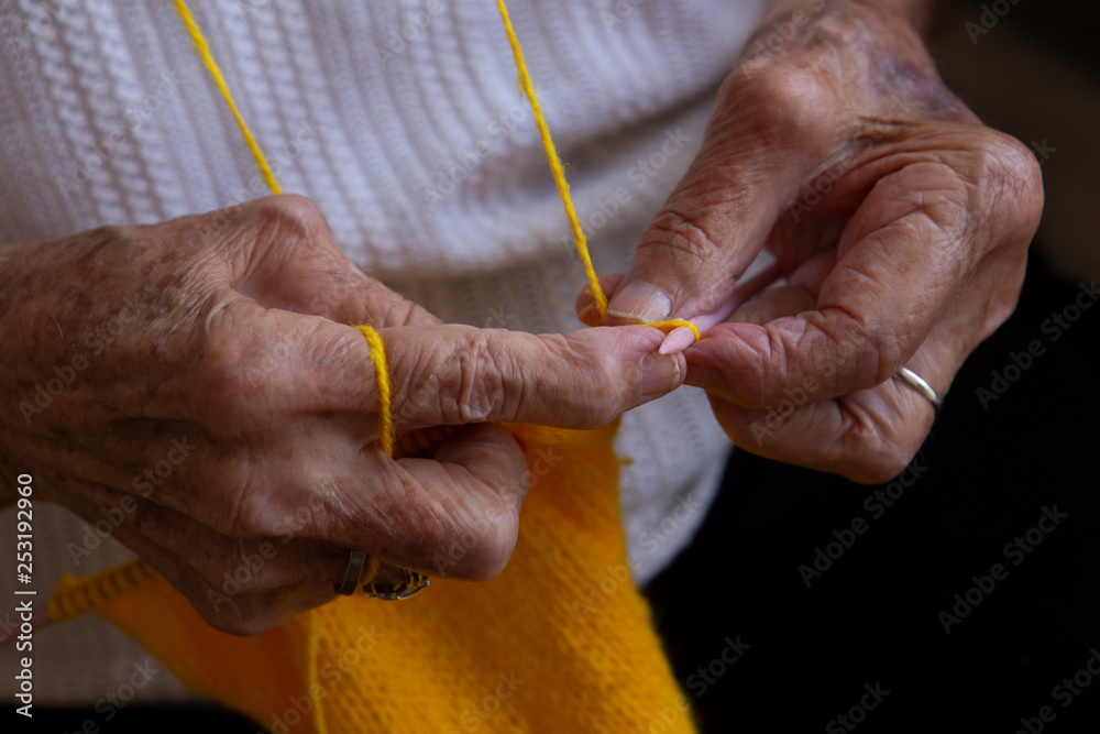 Hands of an old woman knitting needles