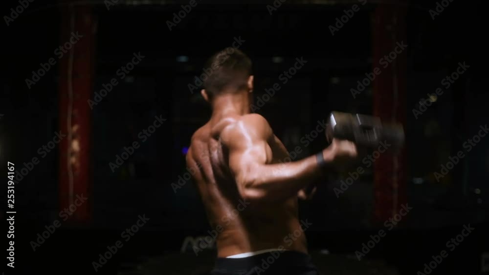 Sport muscular fitness man hitting wheel tire with hammer sledge in gym strong man fitness and bodybuilding training workout fitness concept Sport muscular fitness man hitting wheel tire with hammer sledge in gym strong man fitness and bodybuilding training workout fitness concept