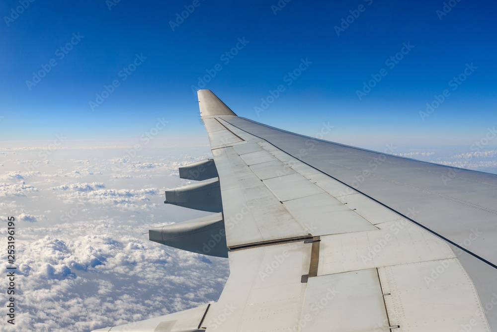 Beautiful clear deep blue sky above skyline of desert earth surface at troposphere atmosphere viewed from airplane's window located over airplane's wing and jet.
