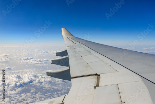 Beautiful clear deep blue sky above skyline of desert earth surface at troposphere atmosphere viewed from airplane's window located over airplane's wing and jet.