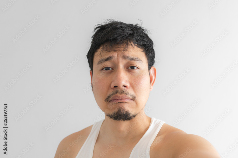 Poor and depressed face of man on grey background. Concept of desperate life. Poor and depressed face of man on grey background. Concept of desperate life.