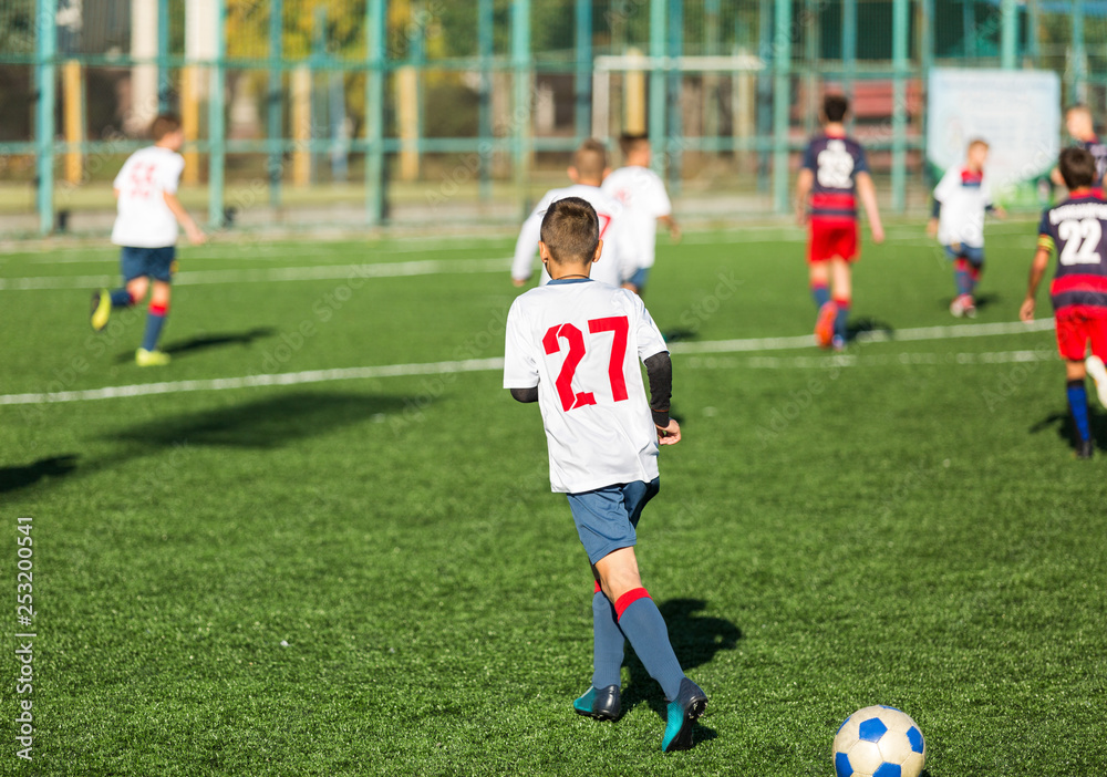 Football training soccer for kids. Boy runs kicks dribbles soccer balls. Young footballers dribble and kick football ball in game. Training, active lifestyle, sport, children activity concept 