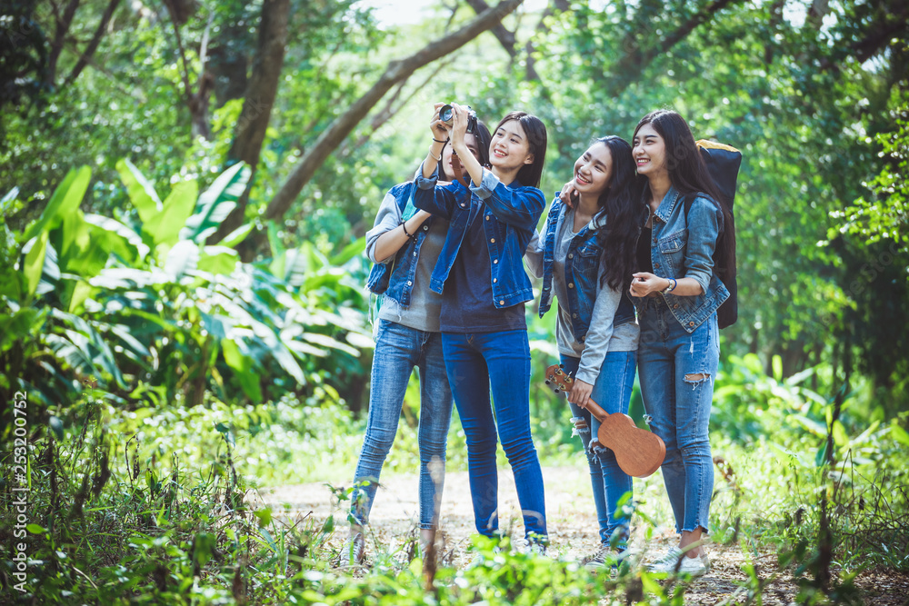 Asian female teenager group walking in the forest amid the green nature of trees and shrubs. Asian female teenager group walking in the forest amid the green nature of trees and shrubs.