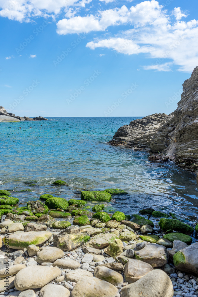 Italy, Cinque Terre, Vernazza, a rocky beach next to a body of water Italy, Cinque Terre, Vernazza, a rocky beach next to a body of water