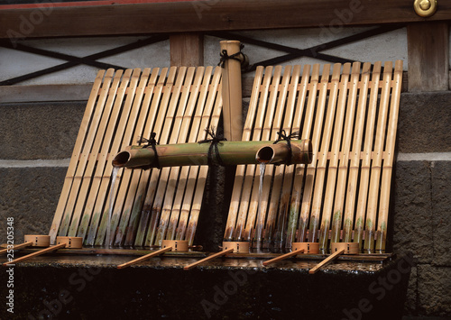 Japanese bamboo drinking water system with water flowing background photo