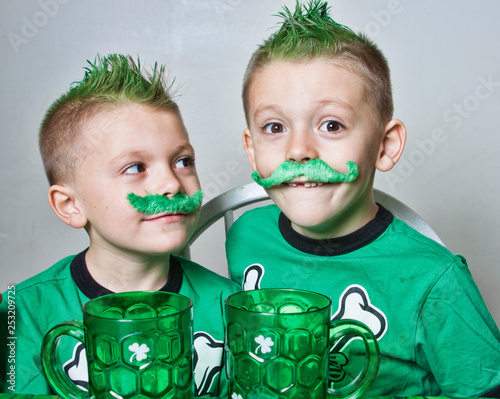 Twin brothers Irish boys with green mohawks and mustaches , ready for St Patrick's Day photo