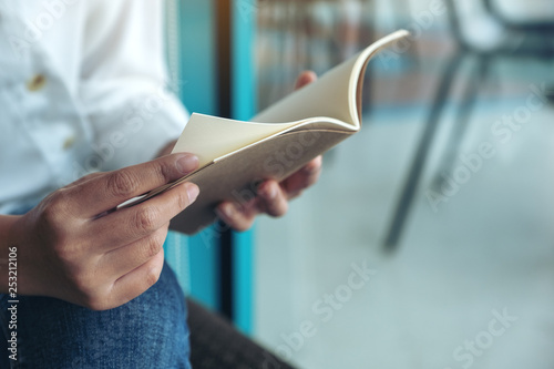Closeup image of a woman holding and reading a book