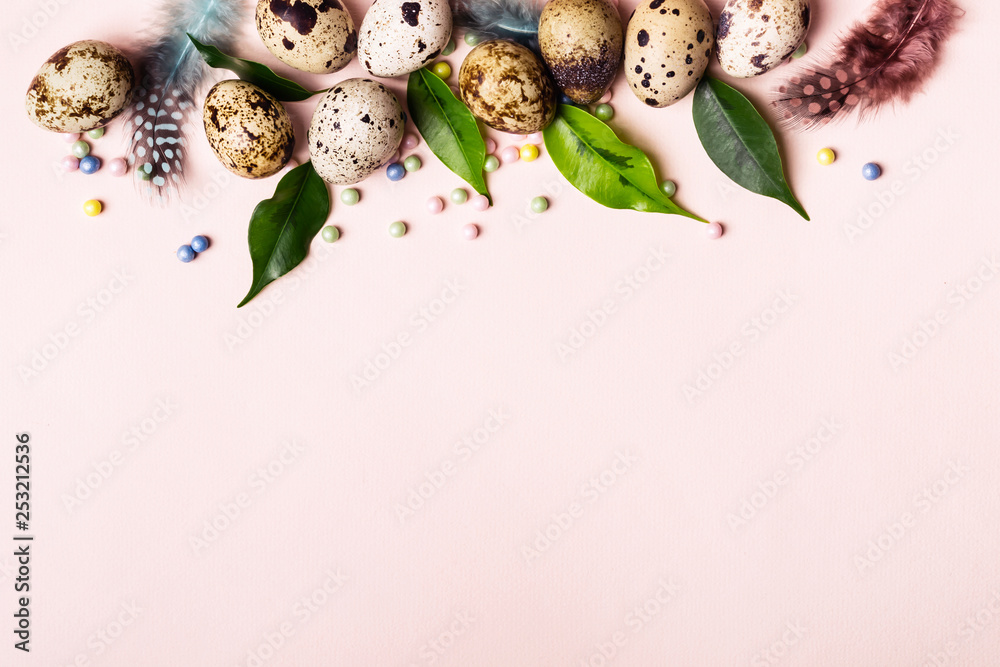 Easter nature border of quail eggs, green leaves and feathers