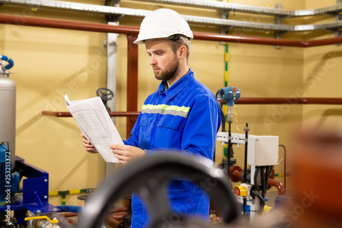 Obraz na płótnie Engineer working with technical documentation during maintenance industrial equipment in refinery plant. w salonie