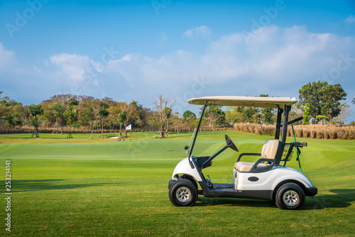 Golf cart park on green grass in golf course ,beautiful view of golf course and sun sky background