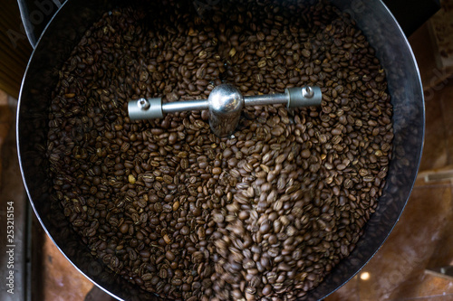 Freshly roasted aromatic Coffee beans in modern coffee roasting machine.