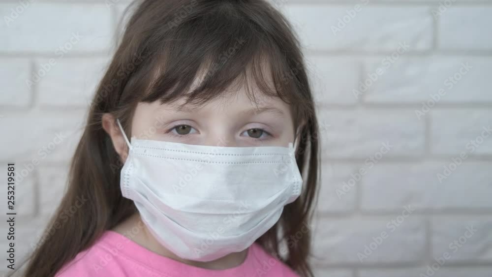 Sad child in a medical mask. Portrait of a cute little girl in a protective mask. Caronavirus protection concept. Sad child in a medical mask. Portrait of a cute little girl in a protective mask. Caronavirus protection concept.
