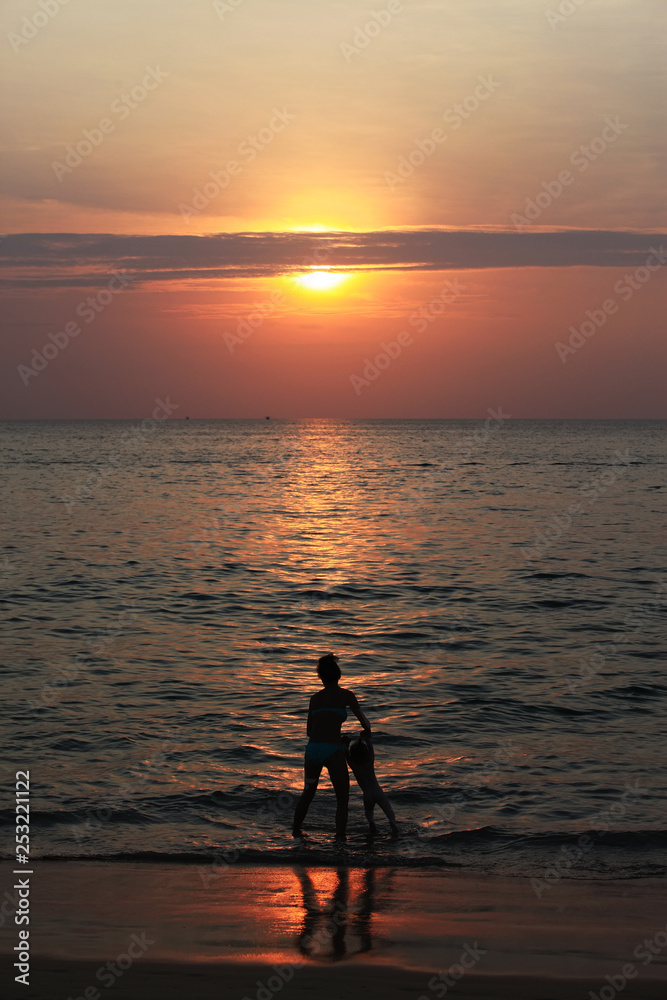Silhouette of adorable little girl on a beach at sunset