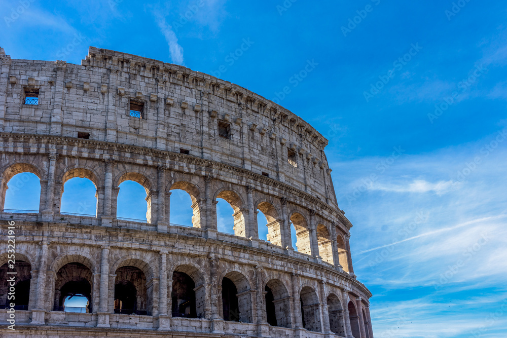 Facade of the Great Roman Colosseum (Coliseum, Colosseo), also known as the Flavian Amphitheatre. Famous world landmark. Scenic urban landscape.
