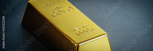 Canvas Print Gold bar ingot bullion on blue background. Located diagonally.