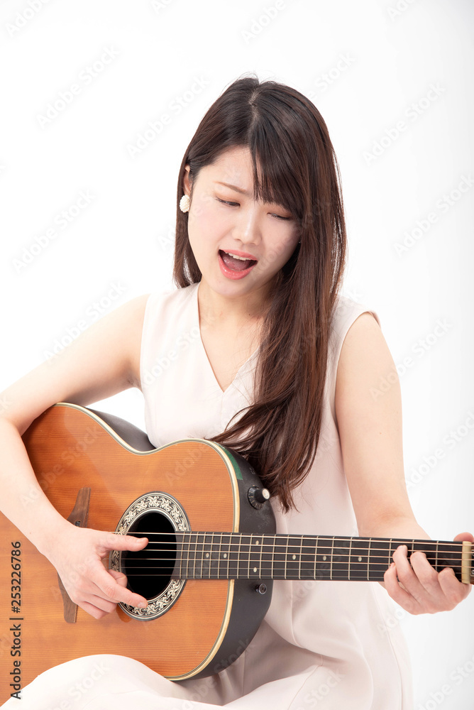 ギターを真剣に弾く女性 ギターを真剣に弾く女性