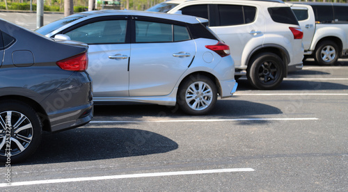 Closeup of back or rear side of blue car and other cars parking in outdoor parking area in bright sunny day.  © Amphon