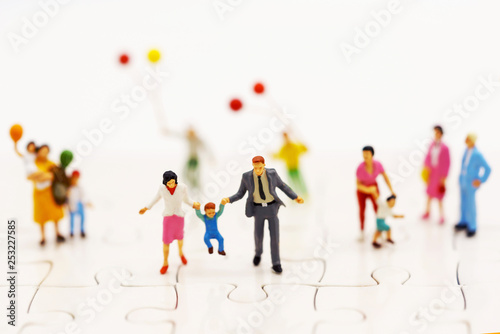 Miniature people: family and children enjoy with colorful balloons, happy family day concept.