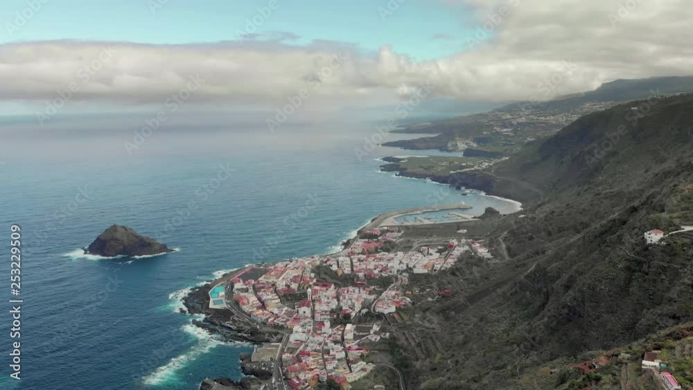 Aerial view of the town of Garachico, North Coast Tenerife, Mediterranean Sea, Canary Islands, natural swimming pools. Sky with clouds, white houses in mountains, north bay. Spain by drone 4k. Aerial view of the town of Garachico, North Coast Tenerife, Mediterranean Sea, Canary Islands, natural swimming pools. Sky with clouds, white houses in mountains, north bay. Spain by drone 4k.
