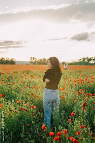 girl is standing with her back in the field with flowers. summer evening. Copy space for text