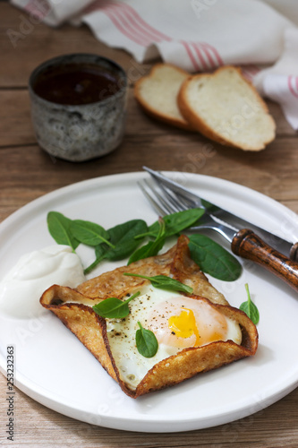 Breton buckwheat crepes with egg, spinach and cream, filed with the coffee. Rustic style.
