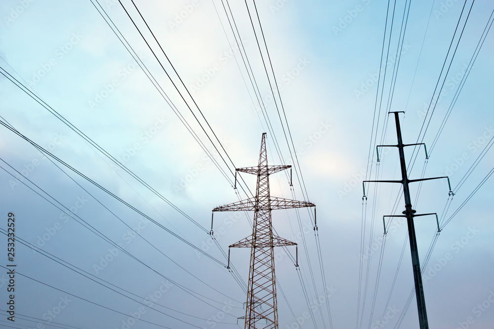 Power lines with many wires and metal supports on the open water against the sky Power lines with many wires and metal supports on the open water against the sky