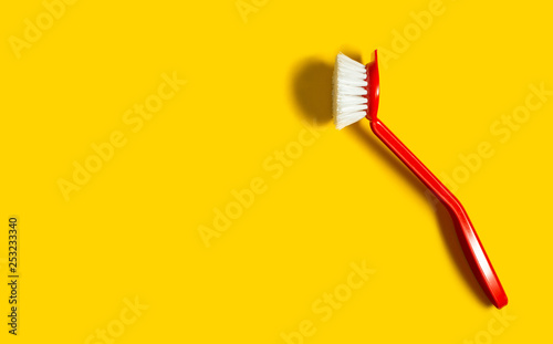 Bright red brush lies on a bright yellow background. In the style of pop art. Top view. Copy space.