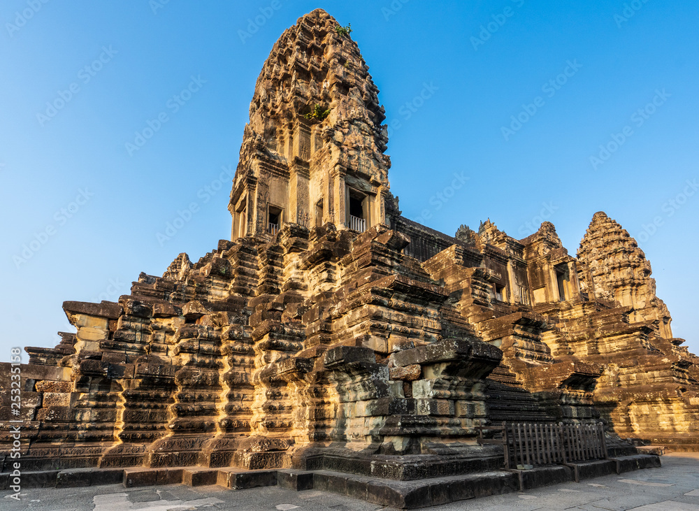 Third level with towers and covered galleries of Angkor Wat temple in golden sunset light