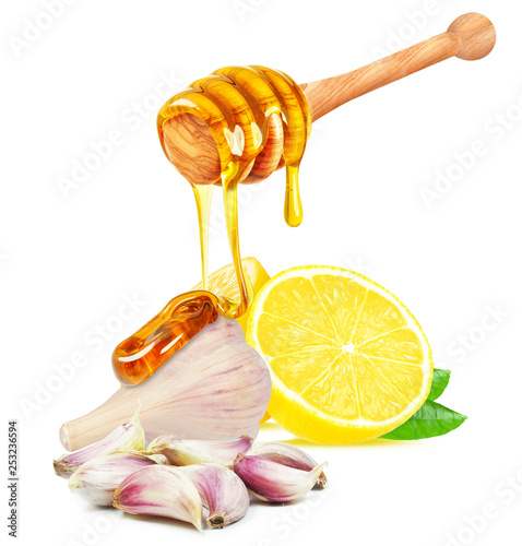 honey dripping on garlic and lemon isolated on white