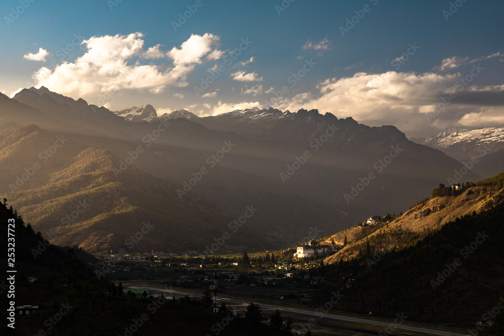 Paro Dzong receiving the last light of the day at sunset in a mountain backdrop