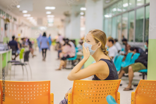 Young woman sitting in hospital waiting for a doctor's appointment. Patients In Doctors Waiting Room photo