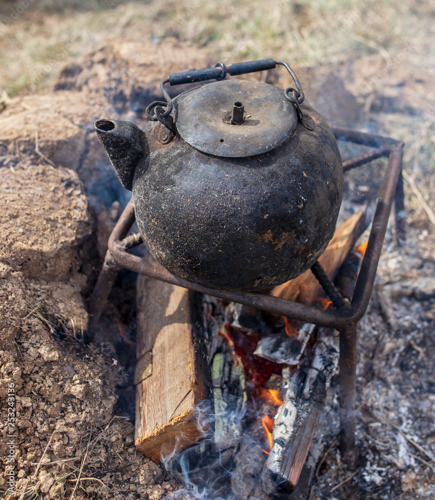 Kettle with water on the fire in nature Kettle with water on the fire in nature