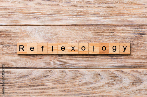 Bilde på lerret reflexology word written on wood block