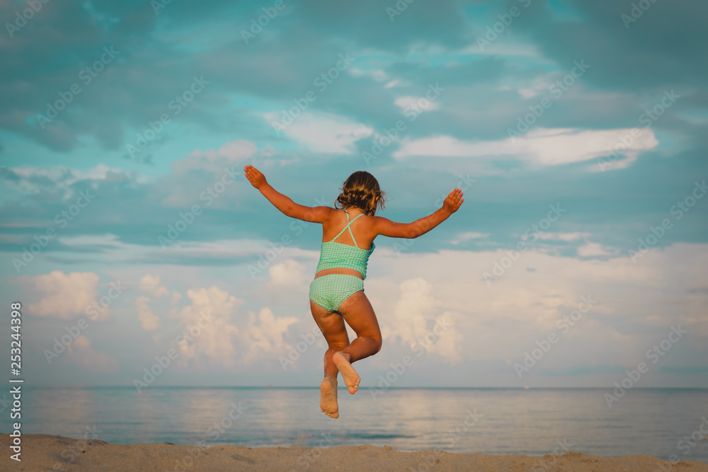 happy little girl enjoy beach, child jump on sea vacation