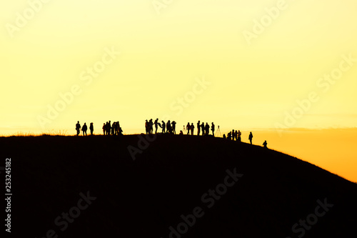 Silhouette of man hold up hands on the peak of mountain success concept