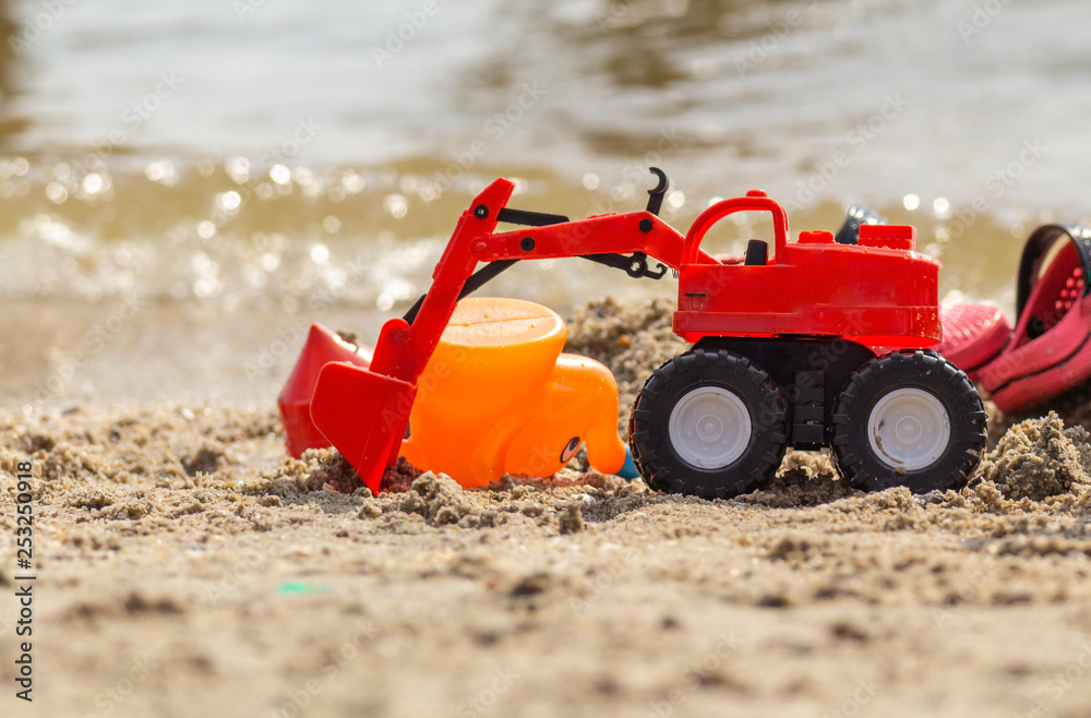 Trackor toy in sand on beach, children activity on holiday. Trackor toy in sand on beach, children activity on holiday.