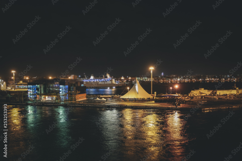 Tilt shift effect of night view of the Bari harbor with moored ferry, Italy