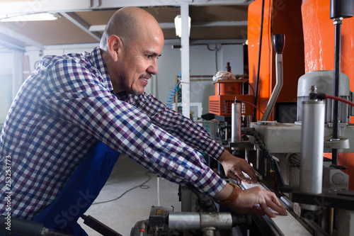 middle age Positive worker at professional lathe in plant