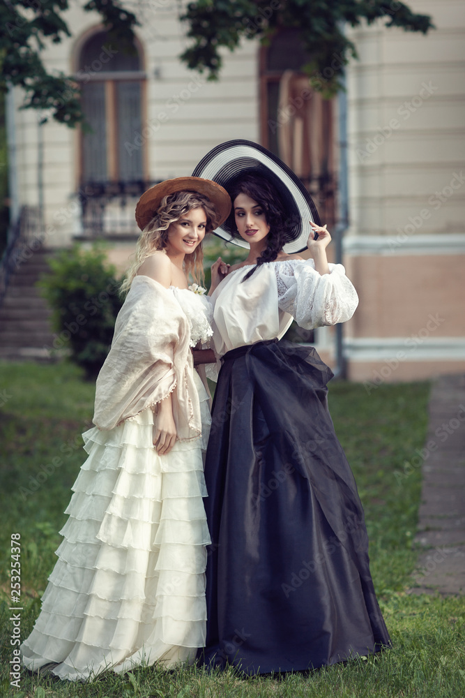 Two girls in vintage clothes and hats