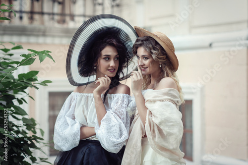 Two girls in vintage clothes and hats