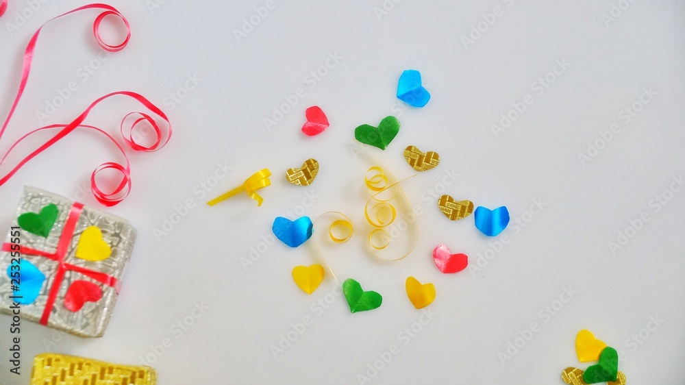 Colourful heart shape ribbon with small gift boxes on colorful bokeh, flare, vintage background. Colourful heart shape ribbon with small gift boxes on colorful bokeh, flare, vintage background.