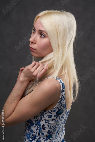 beauty female blond in blue dress on gray background