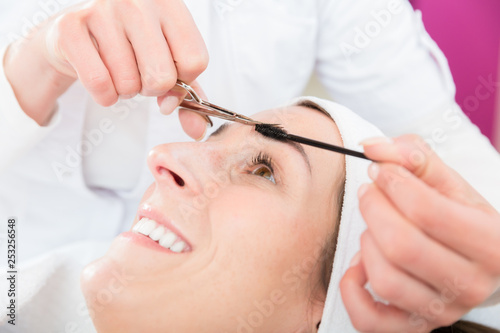 Smiling woman gets eyebrow treatment