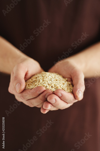 A man with a handful of oat flakes in his hands
