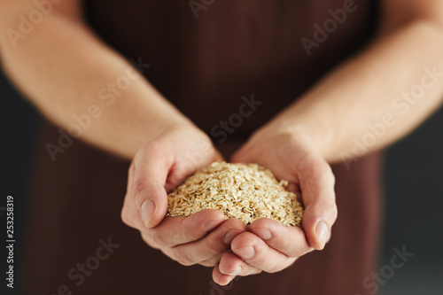 Male hands with a handful of oat flakes