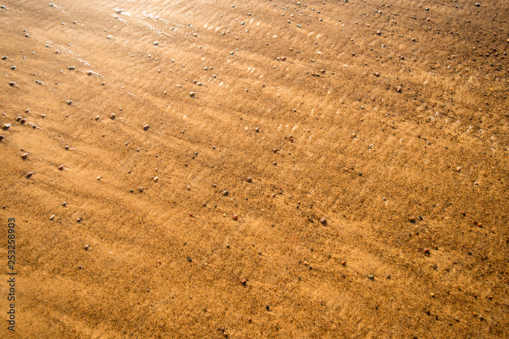 sandy beach with shallow surf and pebbles sandy beach with shallow surf and pebbles